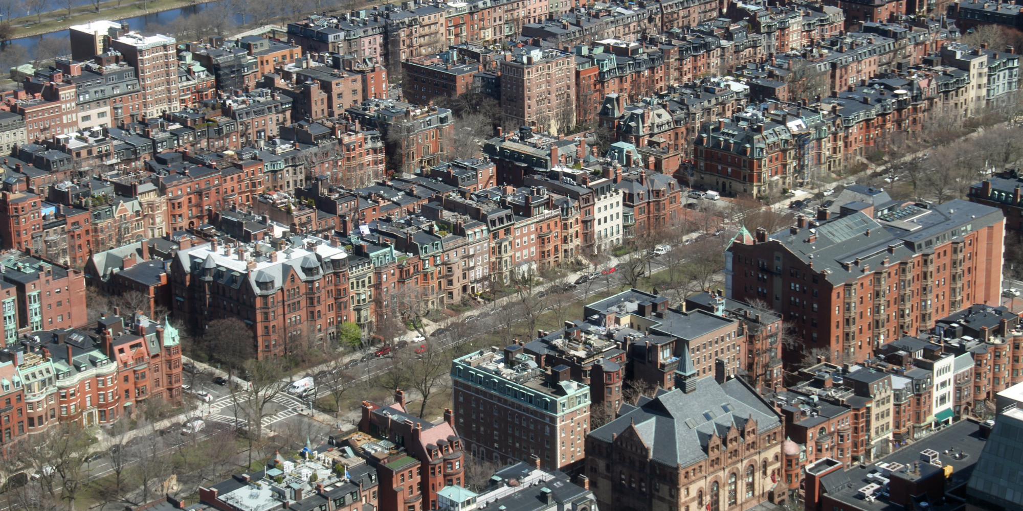 Aerial view of Back Bay Boston illustrating walkable streets, transit access, job proximity, and a vibrant urban lifestyle, along with higher rents, smaller apartments, noise, and limited parking.